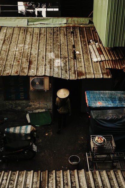 Photo femme portant un chapeau traversant la ruelle