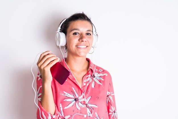 Une femme portant une chemise rouge avec un floral portant un casque heureux