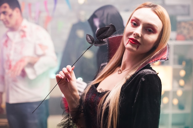 Femme portant un costume de vampire regardant la caméra pour la célébration d'halloween.