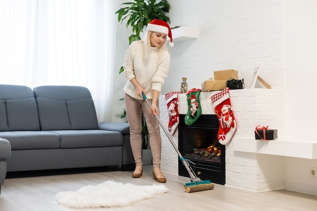 Femme portant des décorations festives prêtes pour le nettoyage après Noël