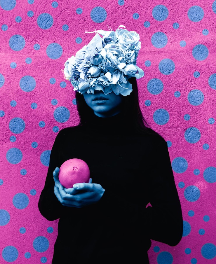 Photo femme portant des fleurs sur les cheveux tenant de la nourriture contre le mur