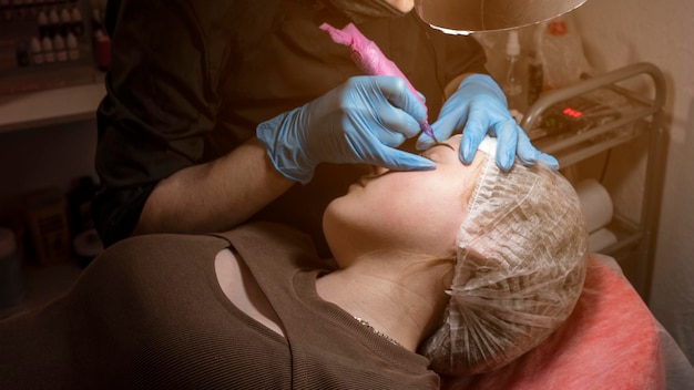 Une femme portant un gant bleu se fait percer le nez.