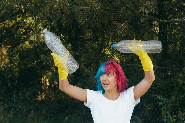 Femme portant des gants tenant des bouteilles en plastique recyclables - concept de pollution en plastique