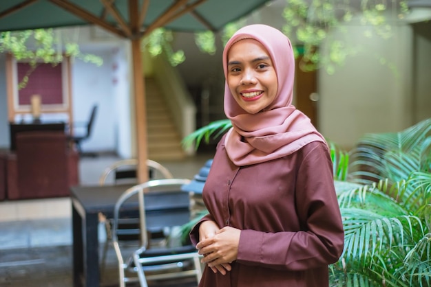 Photo une femme portant le hijab se tient devant un immeuble.