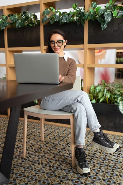 Femme portant des lunettes à l'aide d'un ordinateur portable