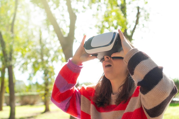 Femme portant des lunettes de réalité virtuelle dans la nature Espace de copie