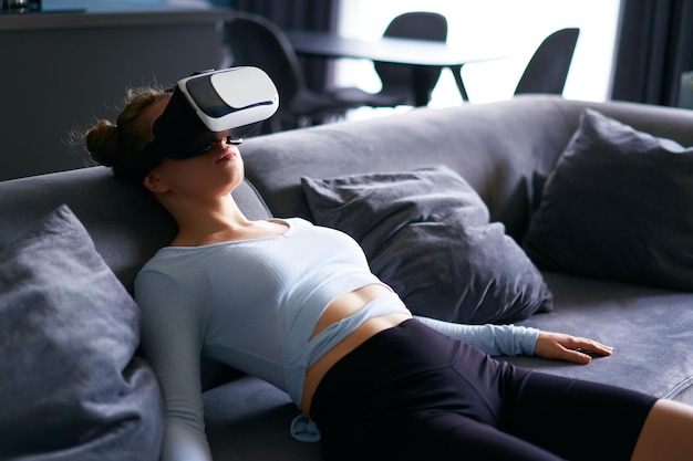 Une femme portant des lunettes de réalité virtuelle entre dans l'expérience immersive du métaverse via l'interface du casque au repos