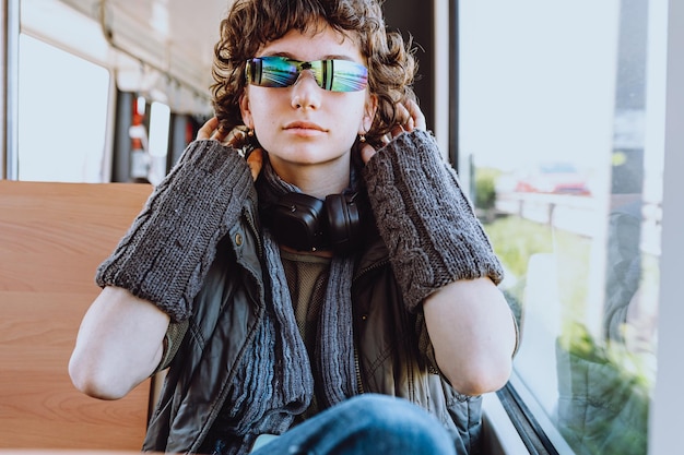 Une femme portant des lunettes de soleil est assise dans un bus et porte des lunettes de soleil