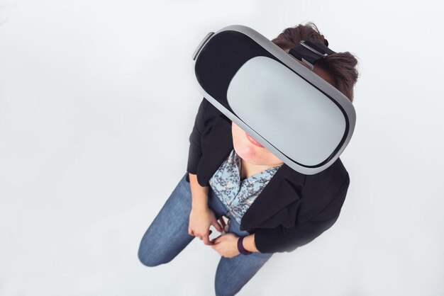 Photo femme portant des lunettes vr alors qu'elle se tient sur un fond gris