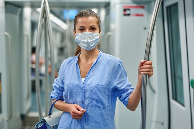 Femme portant un masque chirurgical dans le métro.