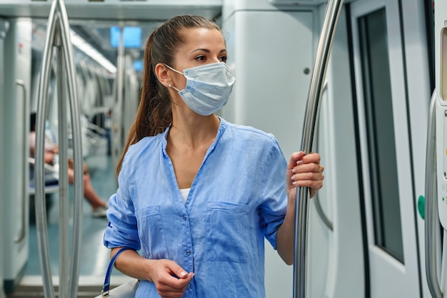 Femme portant un masque chirurgical dans le métro.