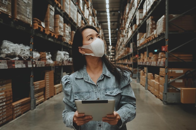 Une femme portant un masque examine l'entrepôt.
