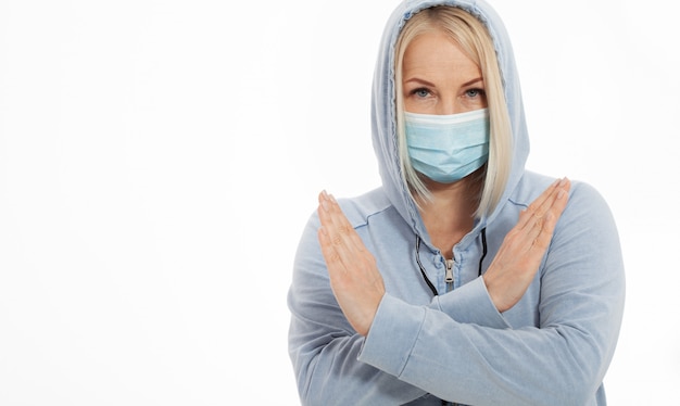 Femme portant un masque facial. Coronavirus concept, virus respiratoire. Signe avec arrêt de mains