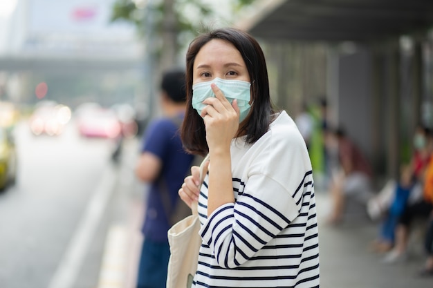 Une femme portant un masque facial protège le filtre contre la pollution de l'air (PM2,5) ou porte du N95