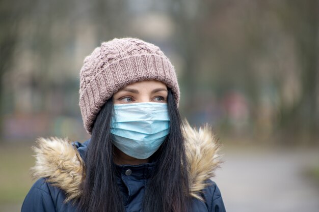 Femme portant un masque facial en raison de la pollution de l'air ou d'une épidémie de virus dans la ville