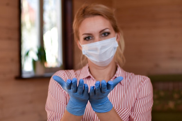 femme portant un masque médical et des gants à la maison