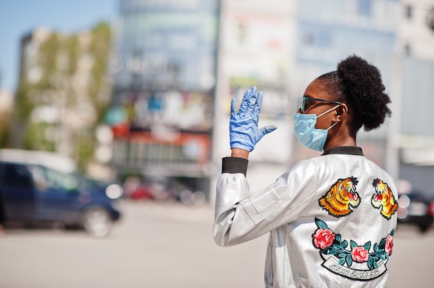 femme portant un masque médical jetable et des gants marcher en plein air pendant la période épidémique.