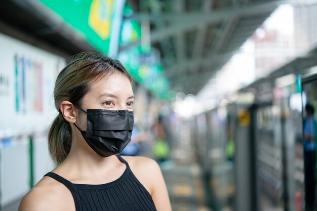 Femme portant un masque pour protéger le virus Covid-19 à la gare de métro