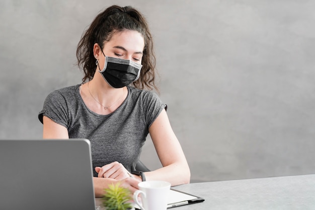 Photo femme portant un masque de protection au bureau d'affaires