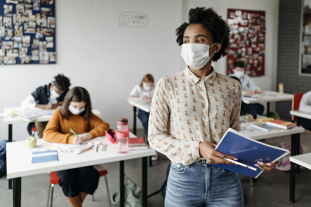 Une femme portant un masque à visage tenant une photo de document