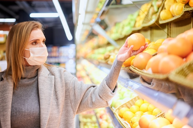 Une femme portant des masques médicaux fait ses courses dans une épicerie pendant la pandémie de virus