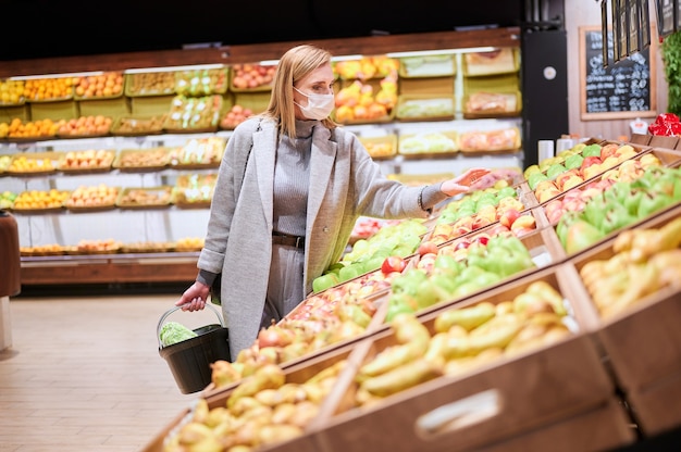 Une femme portant des masques médicaux fait ses courses dans une épicerie pendant la pandémie de virus