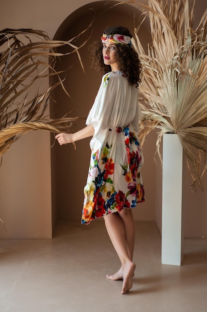 Femme portant une robe à fleurs blanche avec un chemisier blanc