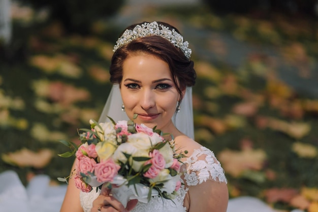 Une femme portant une robe de mariée et tenant un bouquet de fleurs
