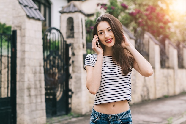 Femme portant un t-shirt rayé avec son téléphone portable