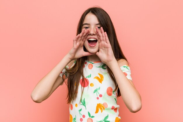 femme portant un vêtement d'été contre un mur rouge criant excité à l'avant.