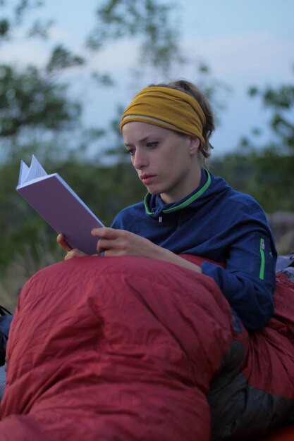 Photo une femme portant des vêtements chauds en lisant un livre