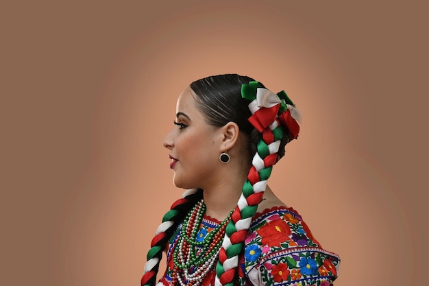 Femme portant des vêtements traditionnels mexicains isolée sur un fond beige