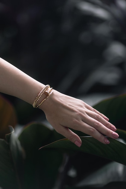 Une femme porte un bracelet en or de la collection de la marque.