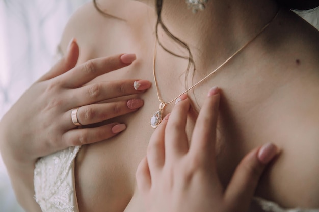 Une femme porte un collier et montre sa poitrine.