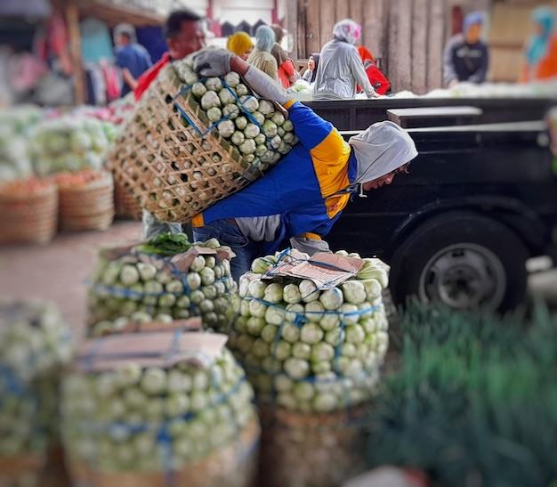 Une femme porte un sac de pois sur la tête.