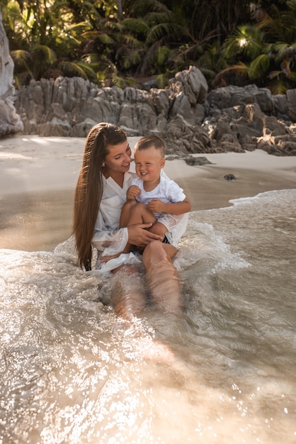 Femme porte son fils dans ses bras en mer