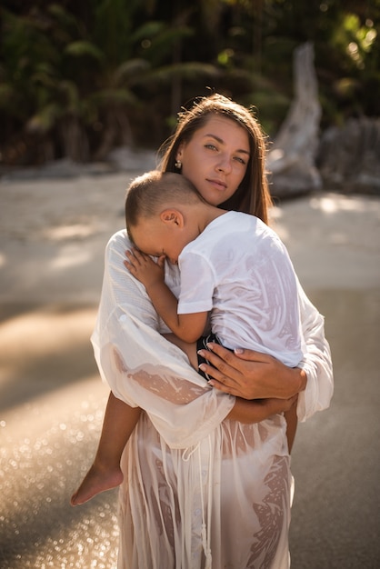 Femme porte son fils dans ses bras en mer