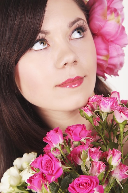 Femme de portrait de beauté naturelle avec la fleur dans les mains