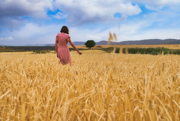 Femme posant dans le champ de blé.