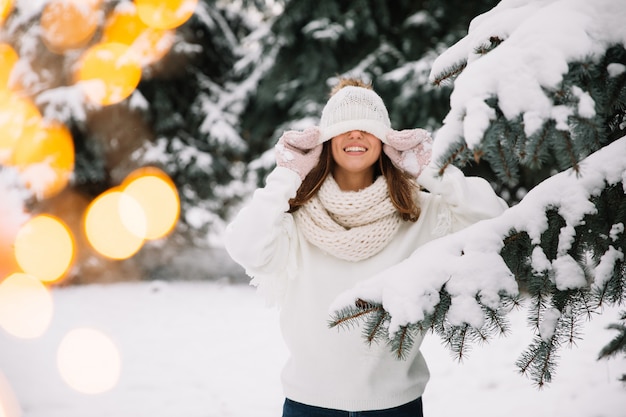 Femme posant dans un parc avec des lumières de Noël. Concept de vacances d&#39;hiver.