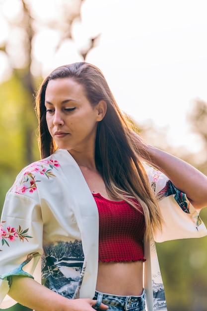 Femme posant dans un parc avec le rayon de soleil qui l'éclaire