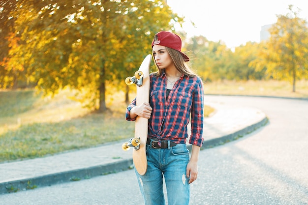 Femme posant avec une planche à roulettes