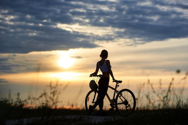 Femme posant près de vélo et de la nature enoying.