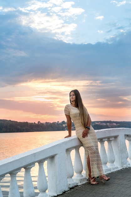 Femme posant en robe avant le lac dans la ville moderne