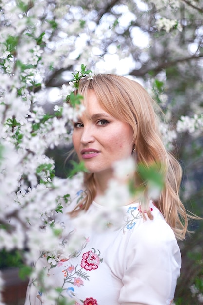 femme posant sous un arbre avec des fleurs