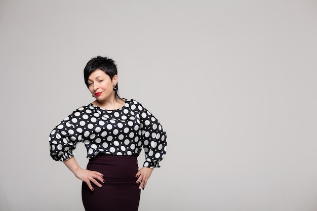 Femme posant en studio sur fond blanc en vêtements de bureau