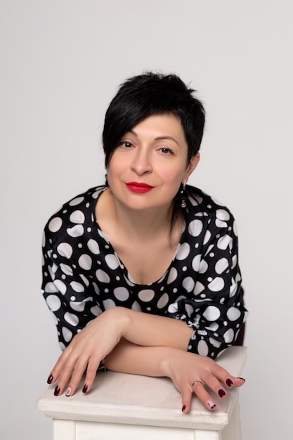 Femme posant en studio sur fond blanc en vêtements de bureau