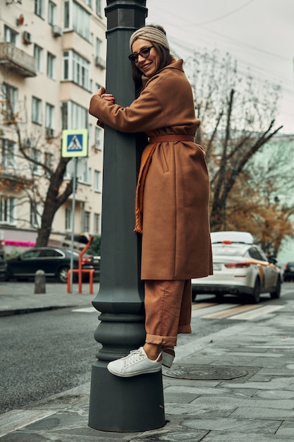 femme pose près d'un poteau de rue. Balades et animations, séance photo dans la ville.