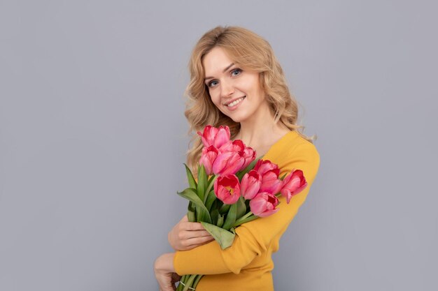 Femme positive avec dame tulipes tenir des fleurs pour les vacances de printemps fille avec bouquet