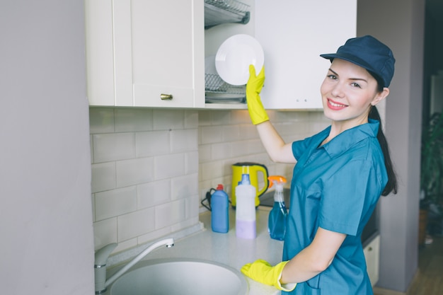 Femme positive et énergique se tient à l'évier